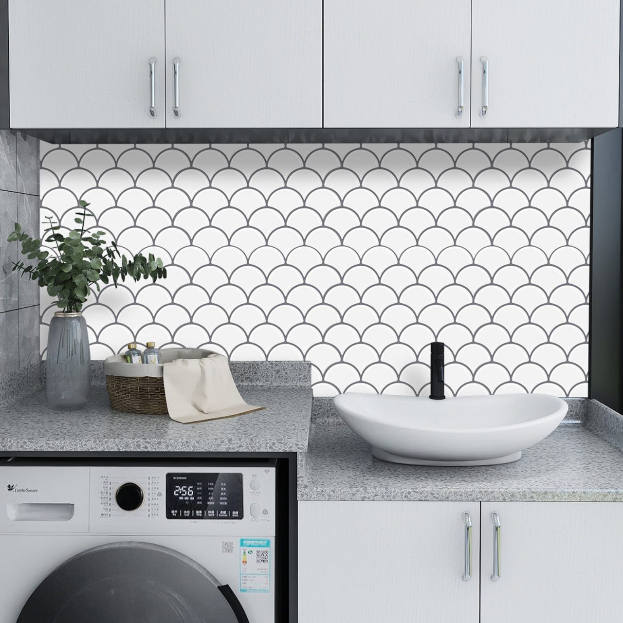 White peel and stick oriental fan tiles with grey grout as a back splash in a laundry room