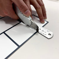 Thumbnail for White subway peel and stick tiles being cut