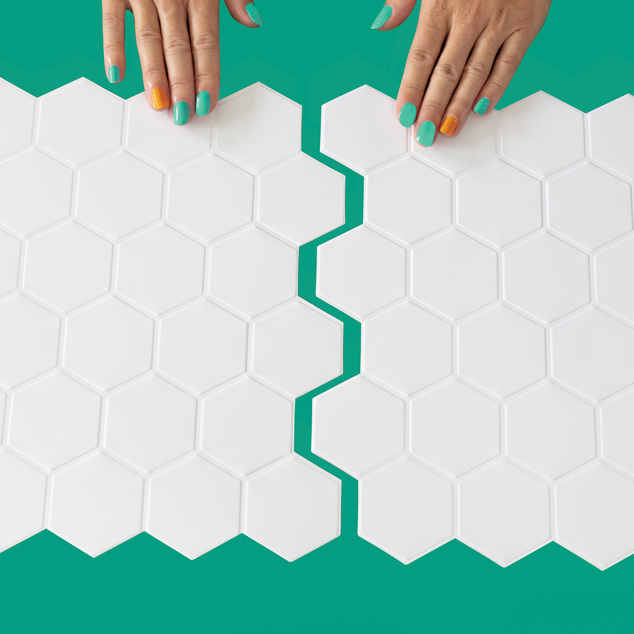 Two white hexagon peel and stick tiles being connected
